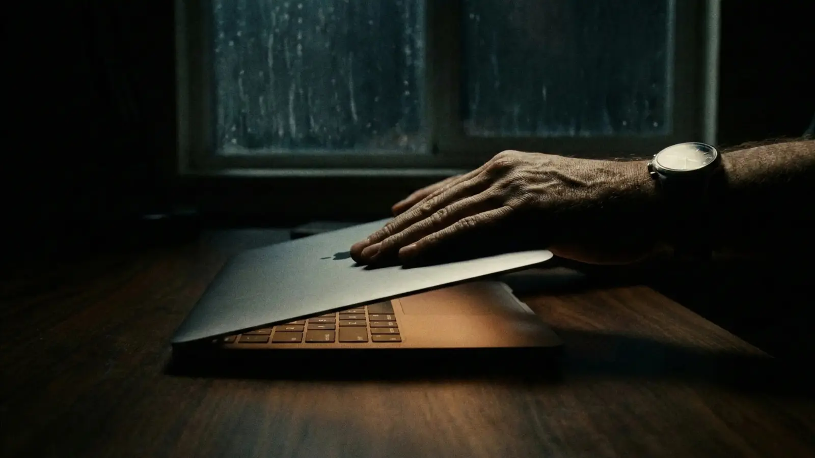 A moody, cinematic close-up photograph in a dark room at night.